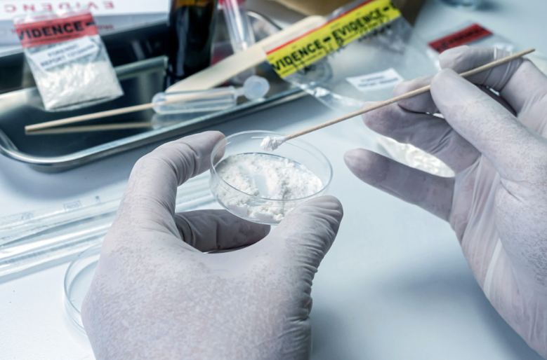 Gloved hands testing evidence and substances